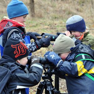 Förskolebarn tittar i kikare