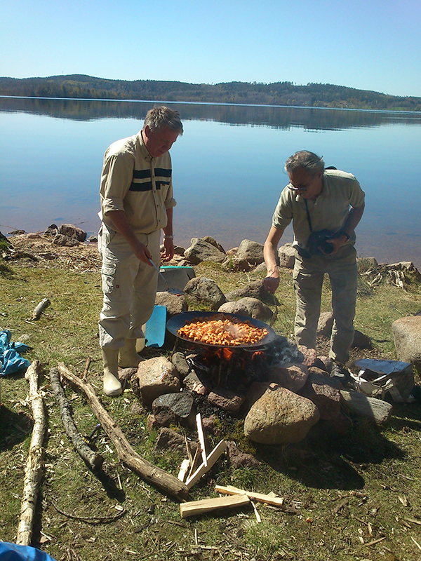 Teambuilding med Ekoturen. Två män lagar mat vid en lägereld