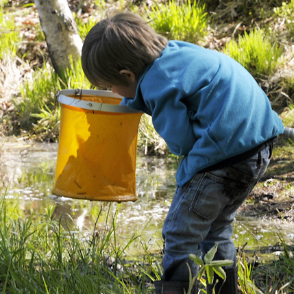 En vuxen står en bit ifrån.